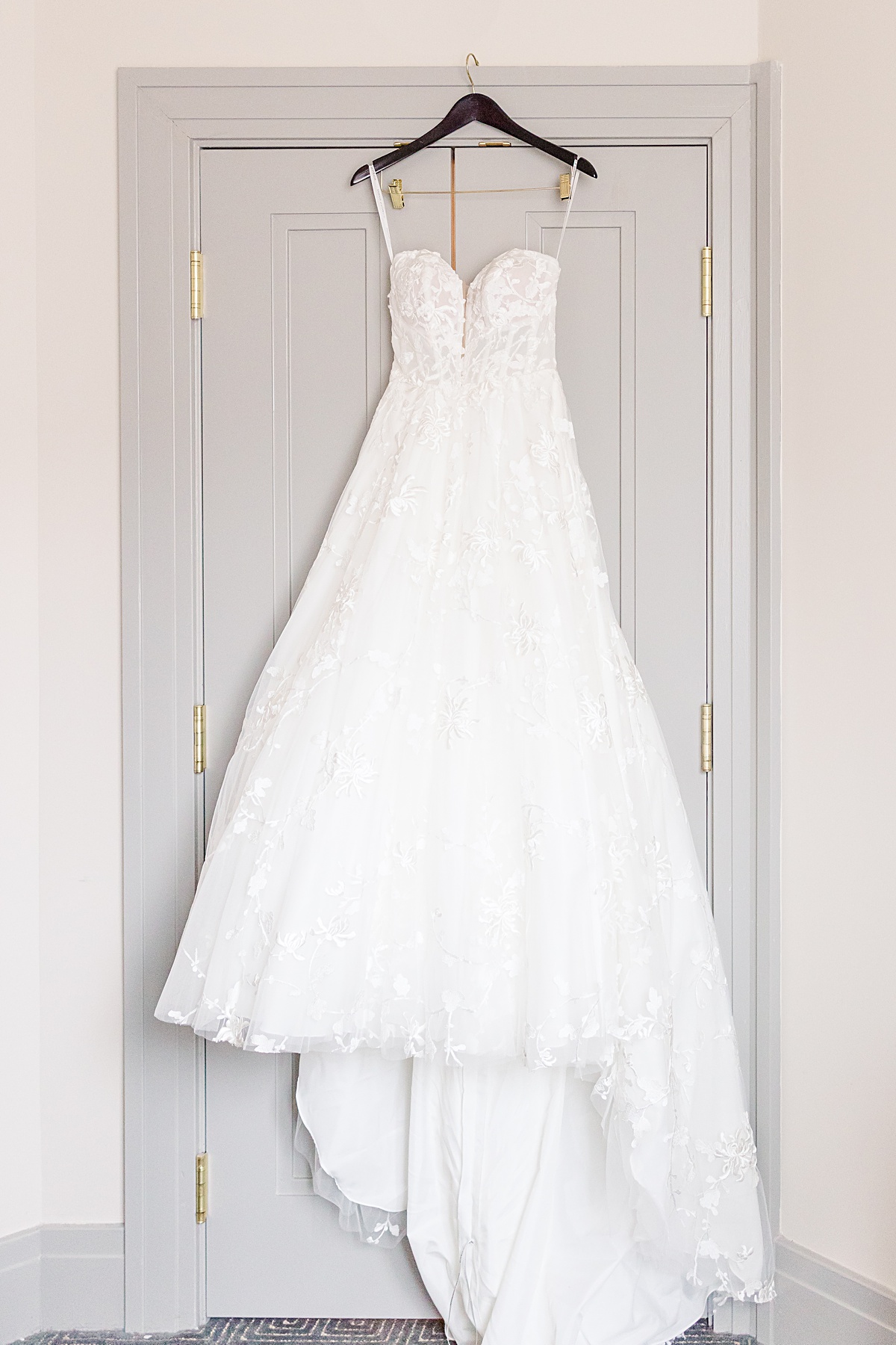 The bride's wedding gown hanging on a door at The Virginian Hotel in Lynchburg, Virginia.