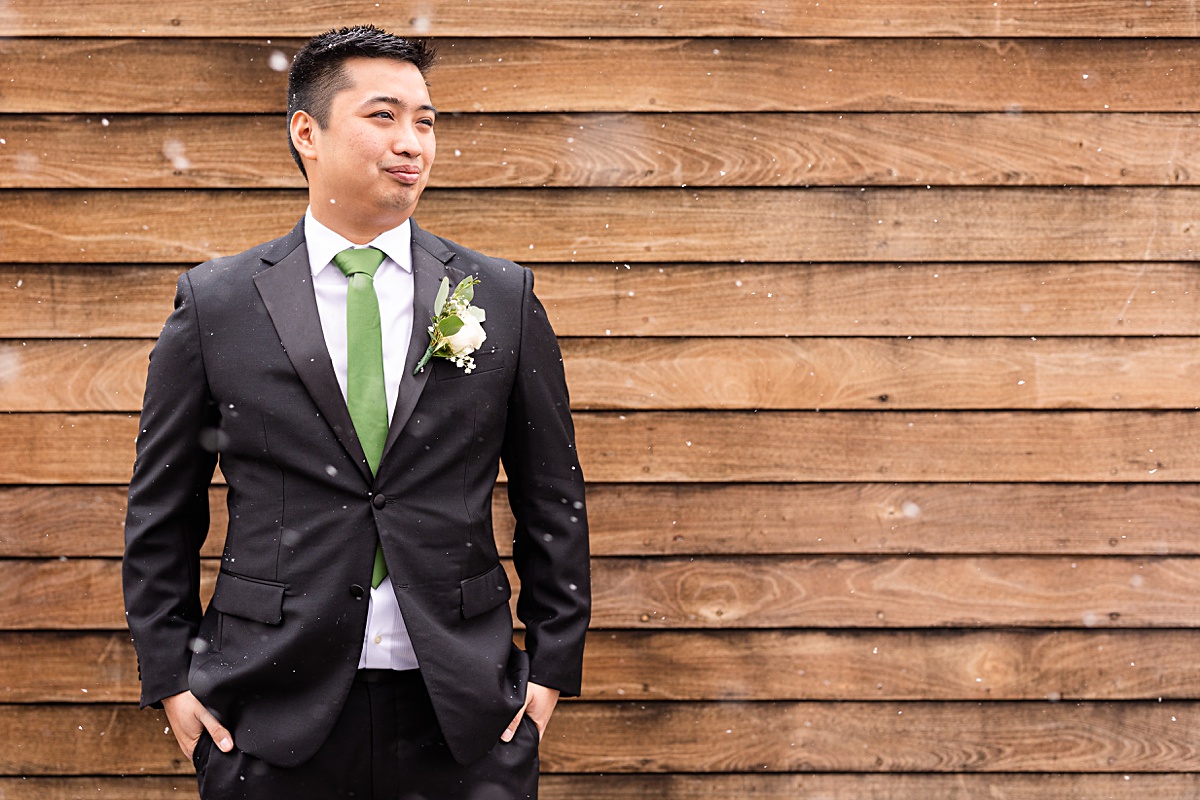 Groom portrait in the snow fall on the Skyline rooftop at The Virginian Hotel in Lynchburg, Virginia.