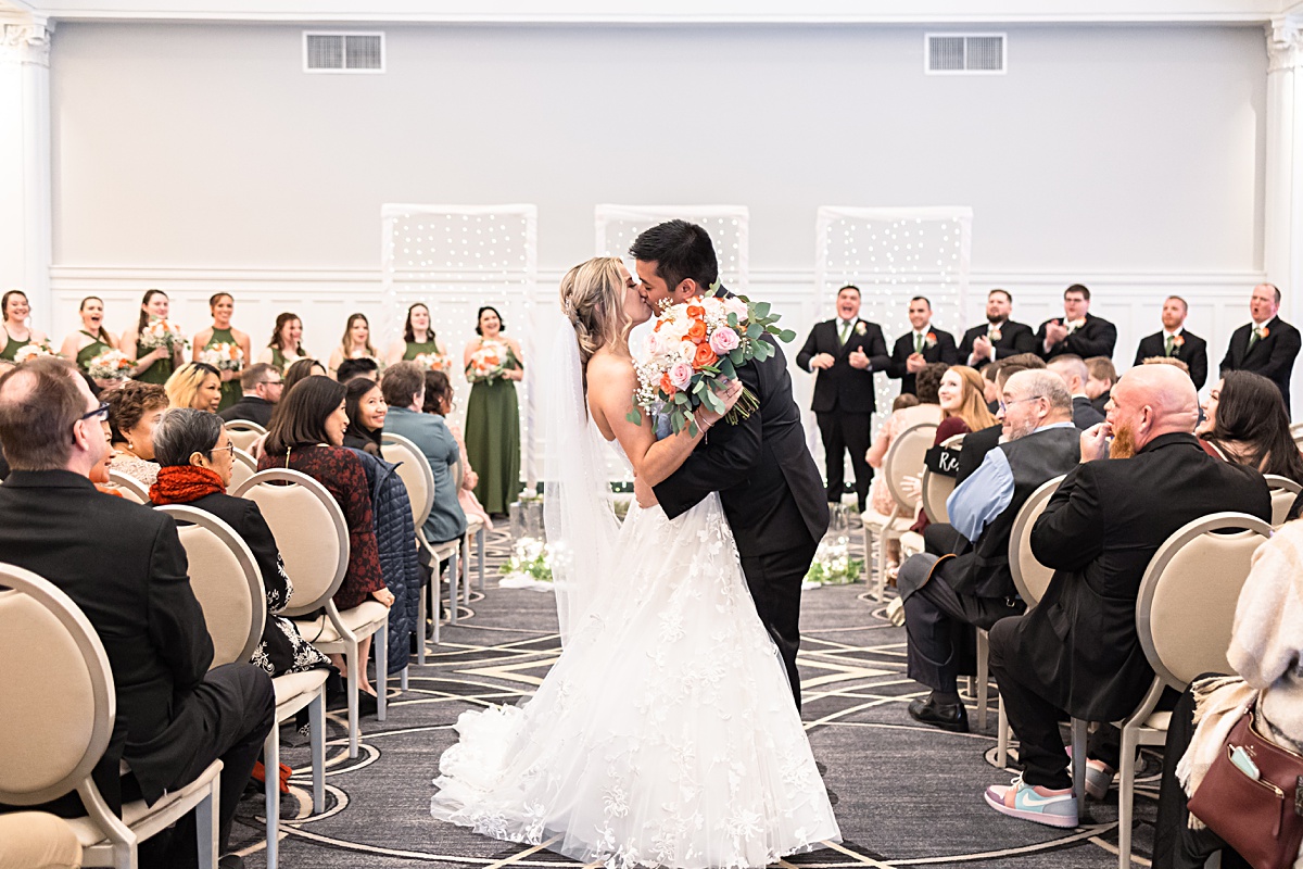 Ceremony photo of the bride and groom sharing their first kiss as husband and wife at their The Virginian Hotel wedding in Lynchburg, Virginia.