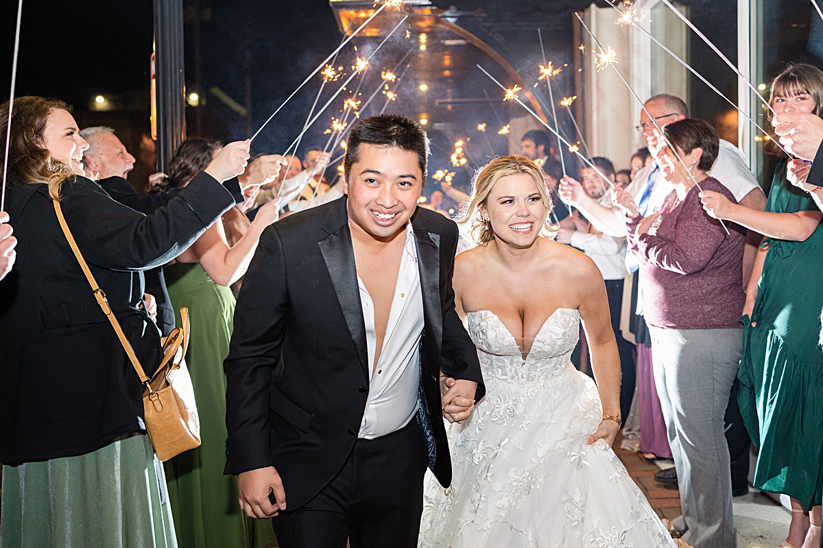 Bride and groom running through their sparkler exit at The Virginian Hotel in Lynchburg, Virginia.