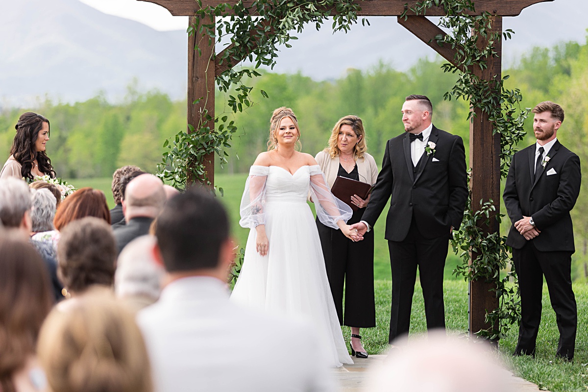 This elegant garden wedding at Cedar Oaks Farm features a classic car, stunning ceremony mountain view, unique bridal details, a boxer puppy, and a surprise baby gender reveal cake!