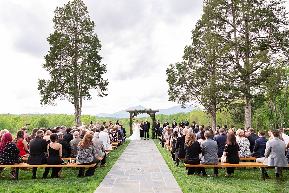 This elegant garden wedding at Cedar Oaks Farm features a classic car, stunning ceremony mountain view, unique bridal details, a boxer puppy, and a surprise baby gender reveal cake!