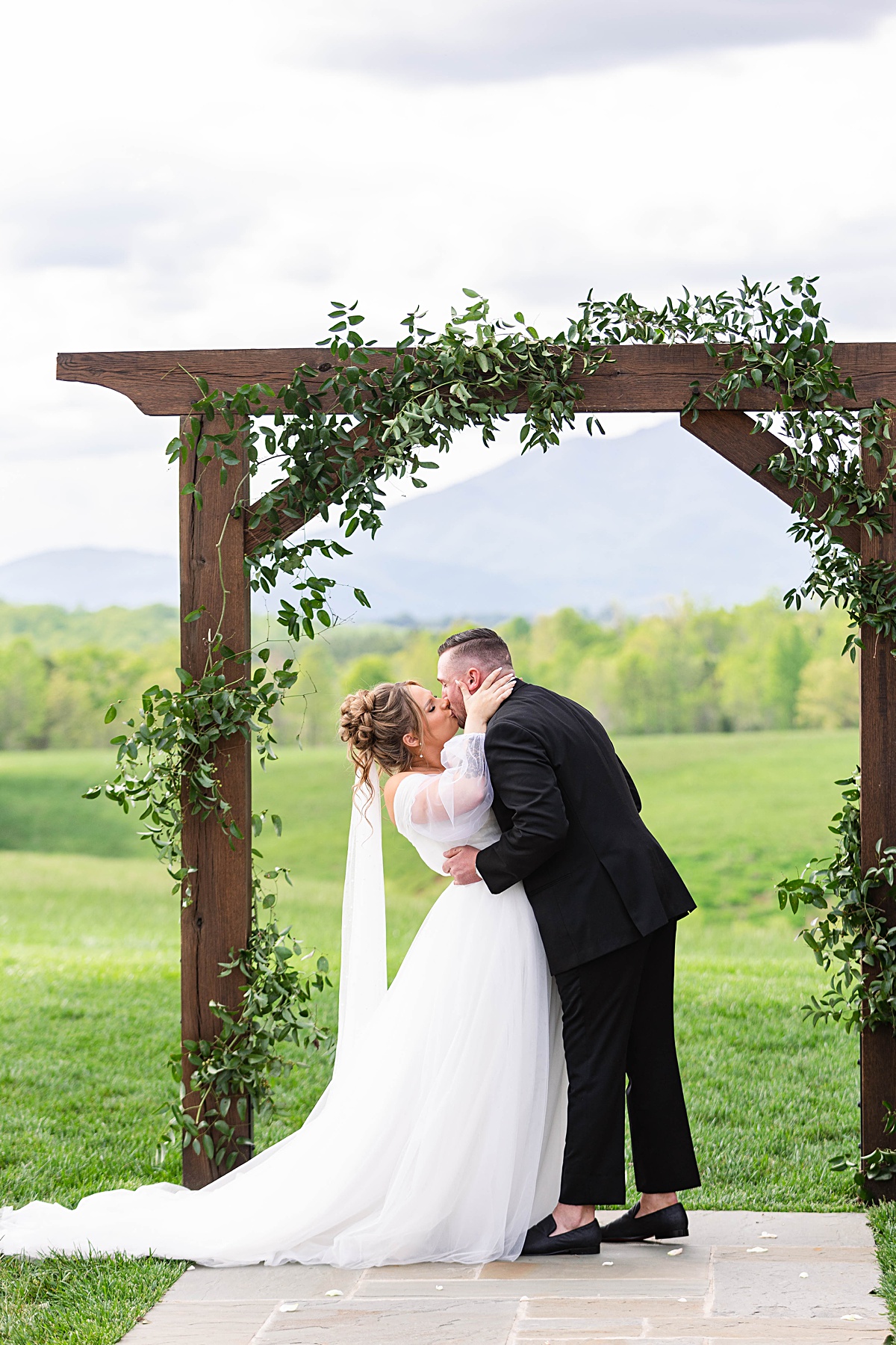 This elegant garden wedding at Cedar Oaks Farm features a classic car, stunning ceremony mountain view, unique bridal details, a boxer puppy, and a surprise baby gender reveal cake!