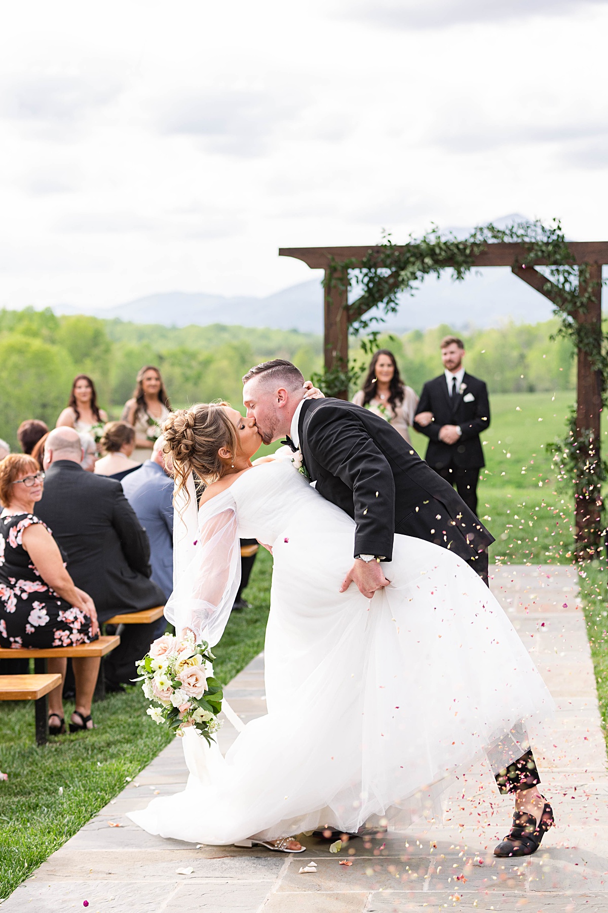 This elegant garden wedding at Cedar Oaks Farm features a classic car, stunning ceremony mountain view, unique bridal details, a boxer puppy, and a surprise baby gender reveal cake!